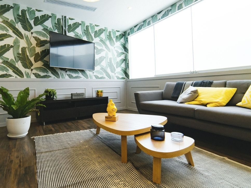 Living room with leafy wallpaper and yellow pillows
